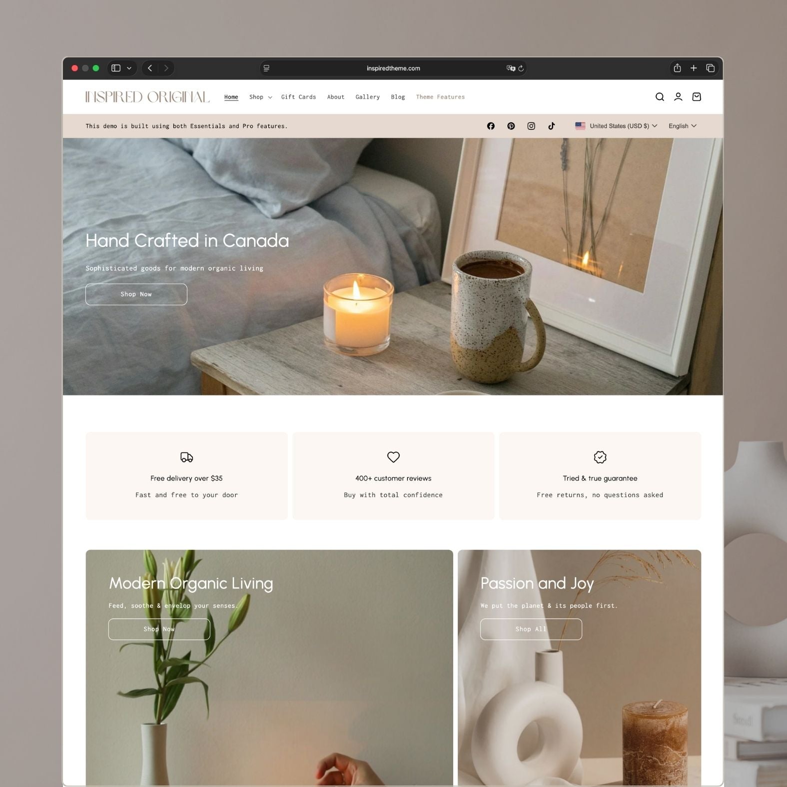 Original Shopify theme homepage for a handcrafted home goods and candle store with warm beige tones, hero banner showing 'Hand Crafted in Canada' over cozy bedroom setting with candle and mug, trust badges, and 'Modern Organic Living' collection cards
